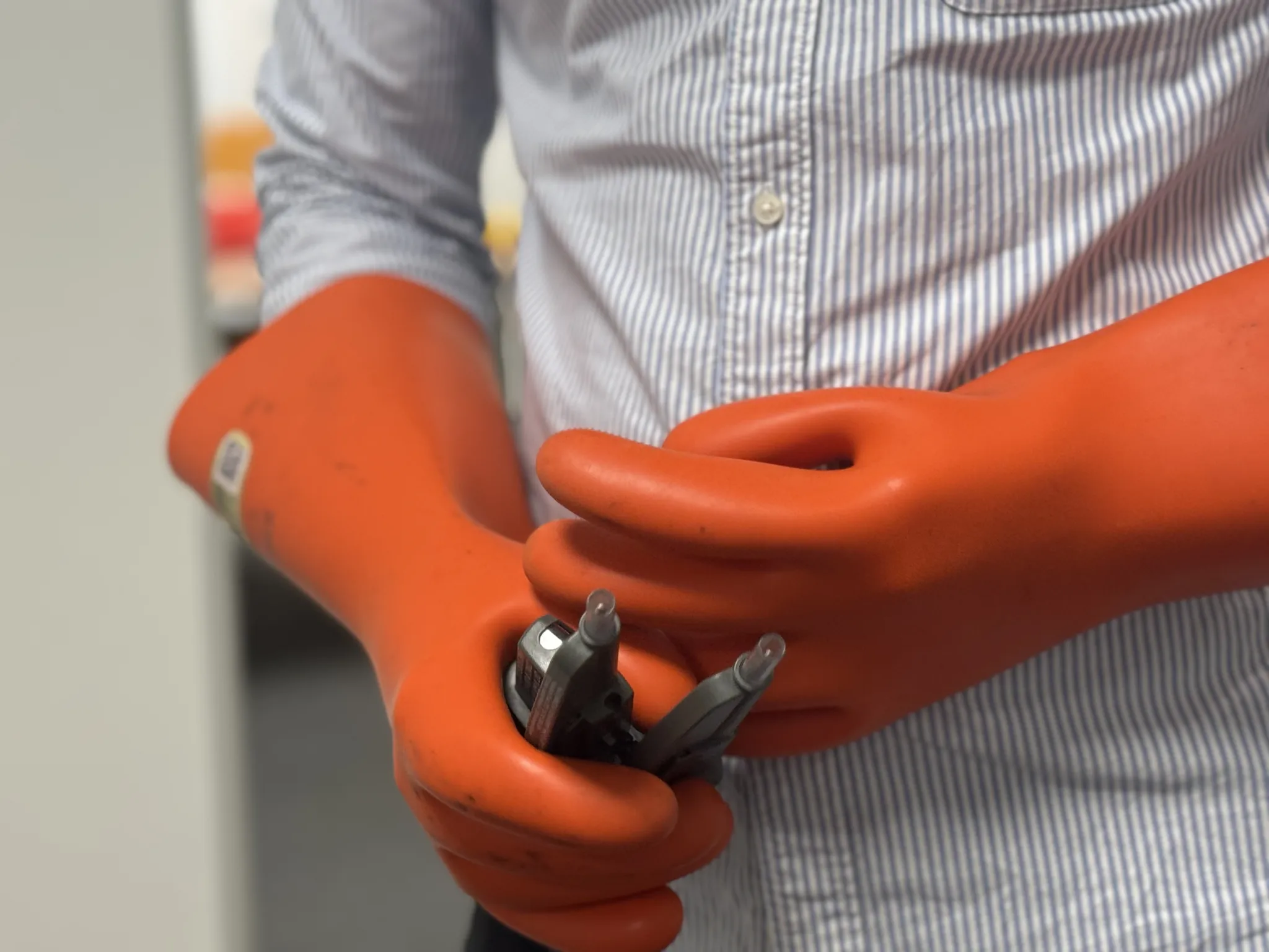 gants-outils-électriques Gants de protection orange tenant des outils électriques